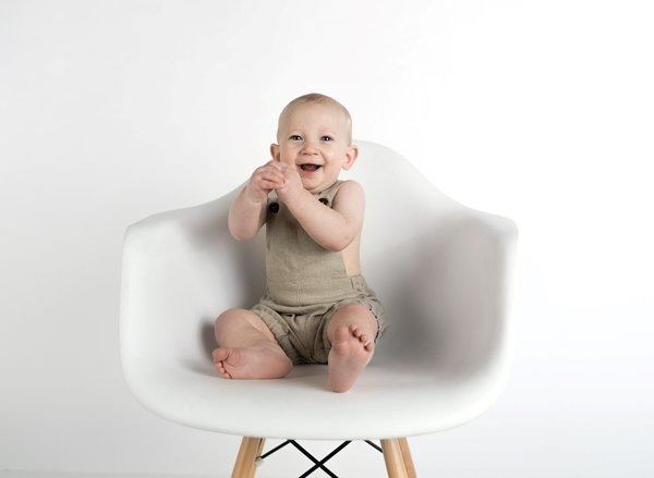 lachendes Kind auf einem Stuhl sitzend